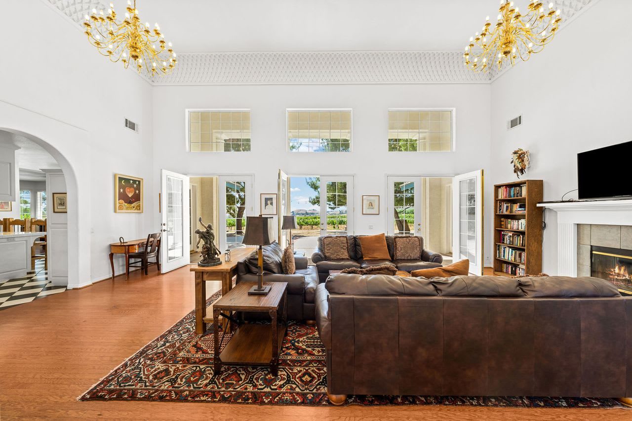 The great room, with chandeliers, a fireplace and built-in bookshelves