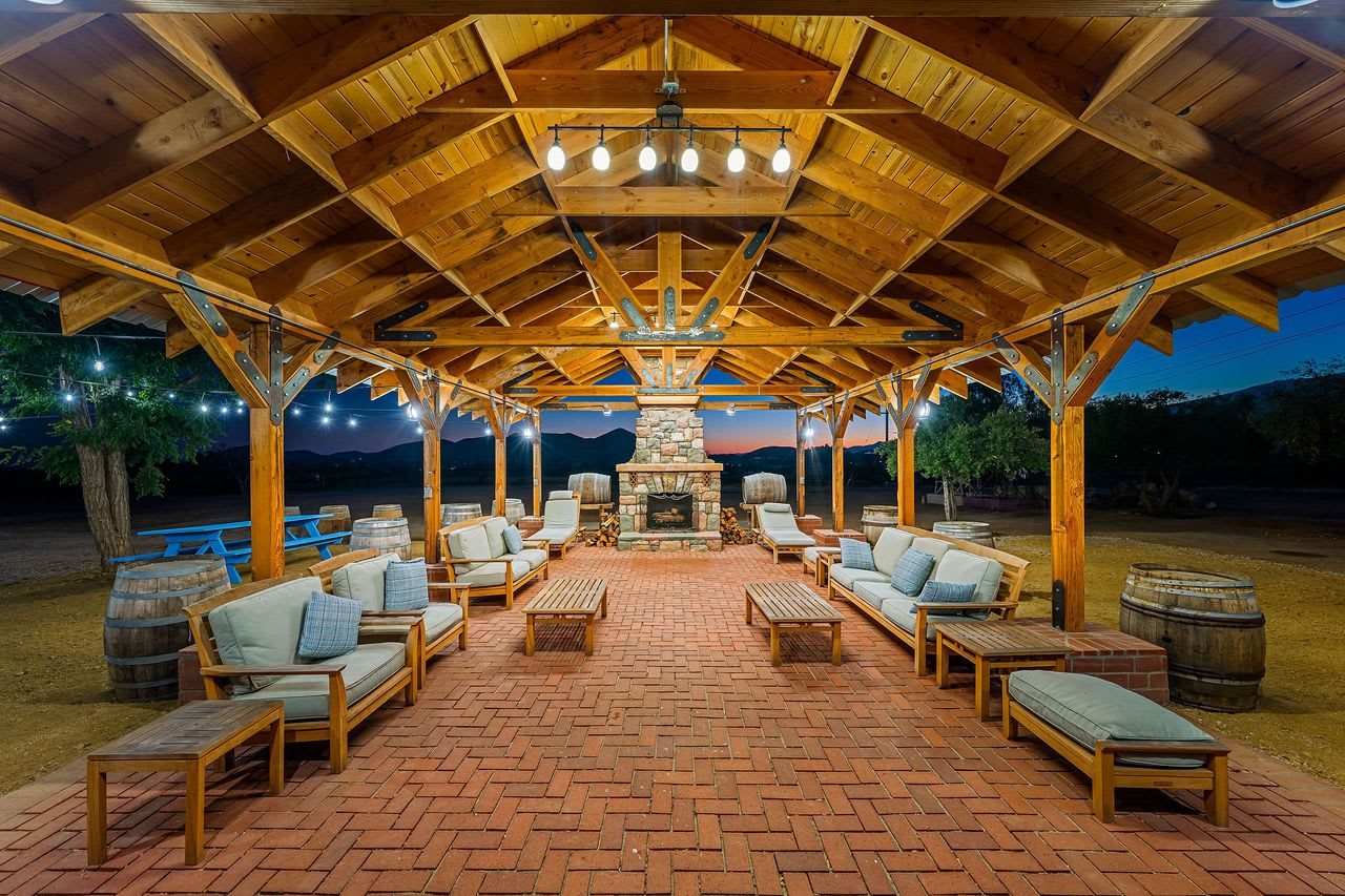 The covered event pavilion, open-sided with a brick floor, wood ceiling and an outdoor fireplace at the far end