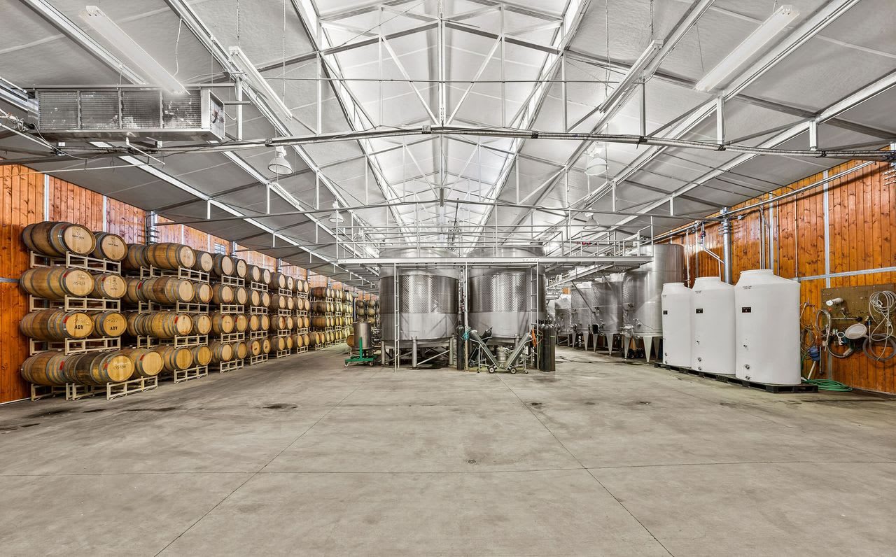Barrels and stainless steel fermentation tanks inside the production building