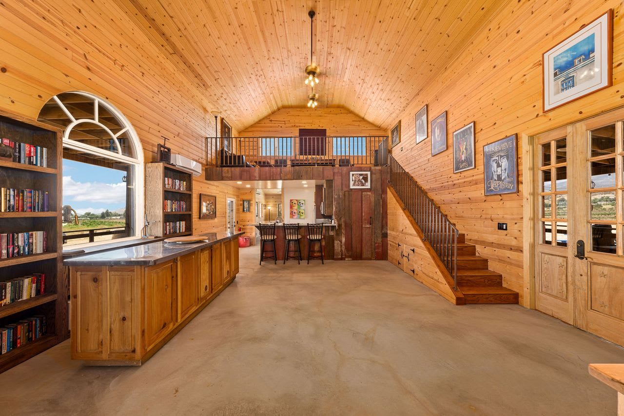 The barn's bar and library wall beneath the loft stair